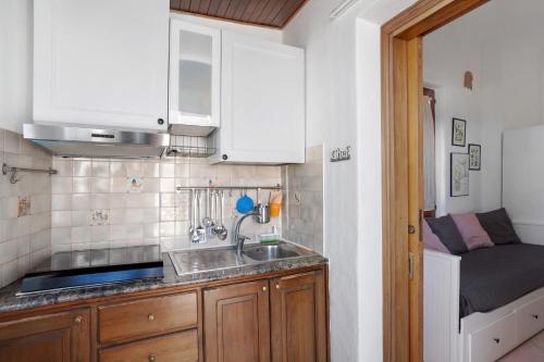 a small kitchen with a sink and a bed at Casatullio - Sant'Angelo d'Ischia in Sant'Angelo D'Ischia