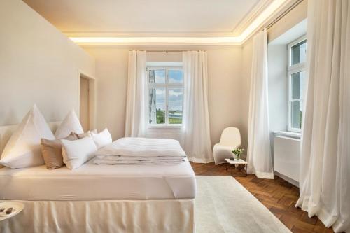 a white bedroom with a bed and a window at Schloss Kirchberg -Appartment Fleur in Immenstaad am Bodensee