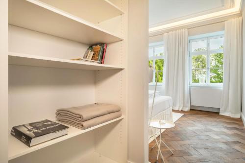 a room with white walls and shelves with books at Schloss Kirchberg -Appartment Fleur in Immenstaad am Bodensee