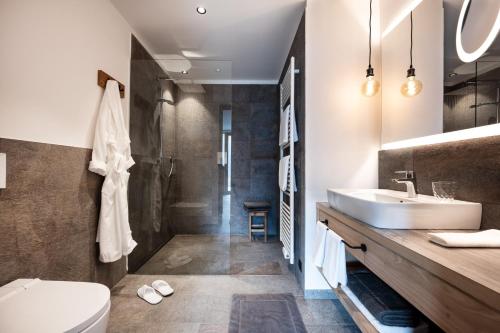 a bathroom with a sink and a toilet and a shower at Oberfallerhof Apartment Inni in Barbiano