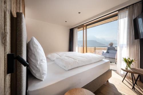 a bedroom with a bed and a balcony at Oberfallerhof Apartment Inni in Barbiano