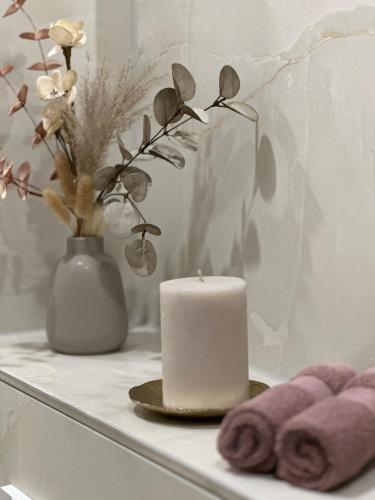 a candle and towels on a counter with a vase at Fewo Sand 10 - Altstadtstudio in Bamberg