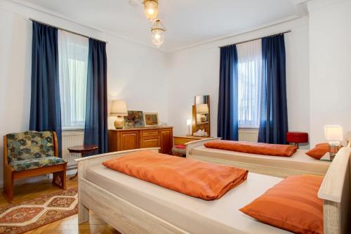a bedroom with two beds and a chair at Siravit Am See in Friedrichshafen