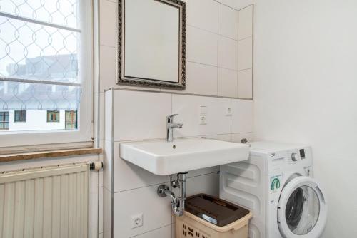 a bathroom with a sink and a washing machine at Siravit Am See in Friedrichshafen