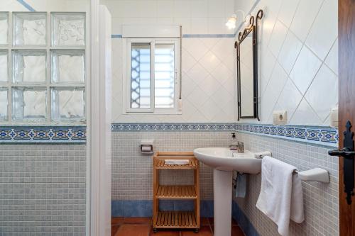 a white bathroom with a sink and a window at Casa - 2 Mar y Sombra in Barbate