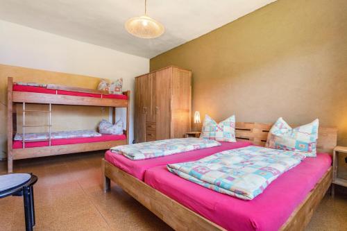 a bedroom with two bunk beds with pink sheets at Kranichnest in Lüdershagen