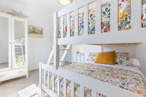 ein Schlafzimmer mit einem Etagenbett und einem weißen Etagenbettgestell in der Unterkunft Ternemoyschool in Pájara