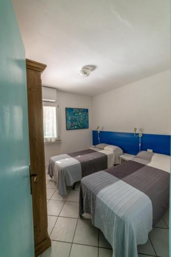 a room with three beds and a blue wall at Il Mirto in Marciana