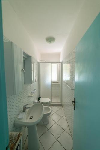 a white bathroom with a sink and a toilet at Il Mirto in Marciana