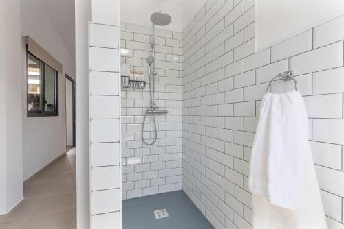 Eine weiß geflieste Dusche mit einem weißen Handtuchhalter in der Unterkunft Ternemoyschool in Pájara