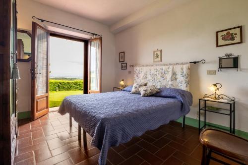 a bedroom with a bed with a blue bedspread and a window at Appartamento Lavanda in Radicofani