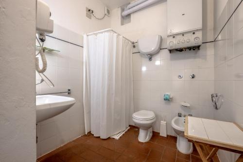 a white bathroom with a toilet and a sink at Appartamento Lavanda in Radicofani