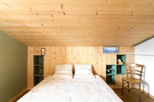 a bed in a room with a wooden ceiling at Logement Pascal in Villeneuve-sur-Lot