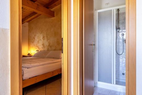 a small bedroom with a bed and a shower at Agriturismo Val d' Egoi 3 in Tremosine Sul Garda