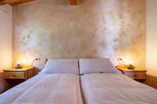 a bedroom with a white bed with two night stands at Agriturismo Val d' Egoi 3 in Tremosine Sul Garda