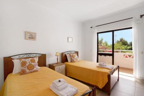 a bedroom with two beds and a balcony at Casa da Oliveira in Loulé