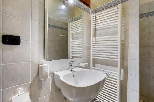 a white bathroom with a sink and a mirror at Lerici – Foyer Verde Mare in Pugliola
