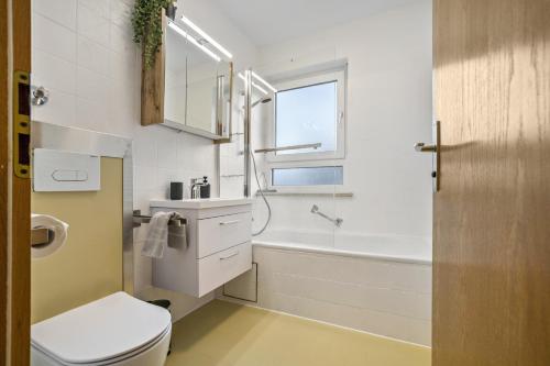 a bathroom with a toilet and a sink and a tub at Fewo mit Bergblick, Pool, Sauna in Oberaudorf