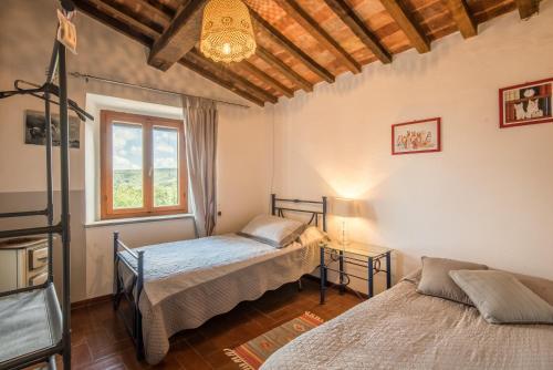 a bedroom with two beds and a window at Glicine in Montieri