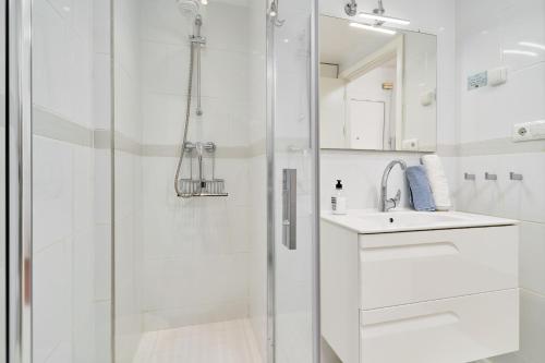 a white bathroom with a shower and a sink at Torresol 208 in Nerja