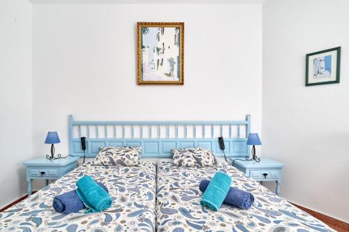 a bedroom with a blue bed with two blue pillows at Torresol 208 in Nerja