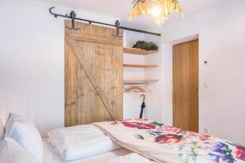 a sliding barn door in a bedroom with a bed at Eichhof Apartment Thymian in Termeno