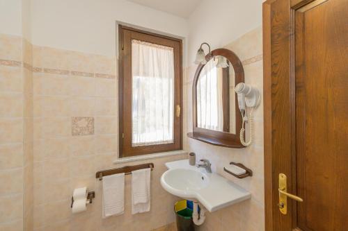 a bathroom with a sink and a mirror at Il Girasole - Cappero in Venturina Terme