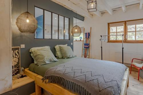 a bedroom with a bed and two pendant lights at La Dordogne en Périgord in Salagnac
