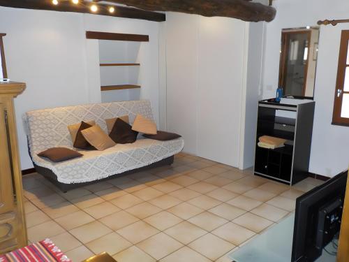 a living room with a couch and a mirror at Le Mas in Arles-sur-Tech