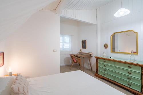 a bedroom with a bed and a dresser with a mirror at Casa Cantina Scalecci in Noto