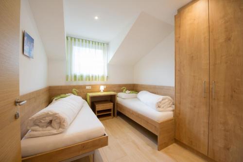 a small room with two beds and a window at Kristallhof Fewo Bergblick in Caldaro