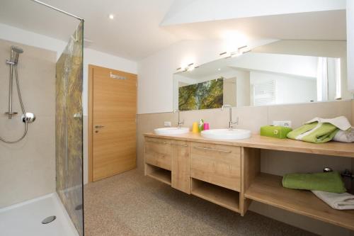 a bathroom with two sinks and a mirror at Kristallhof Fewo Bergblick in Caldaro