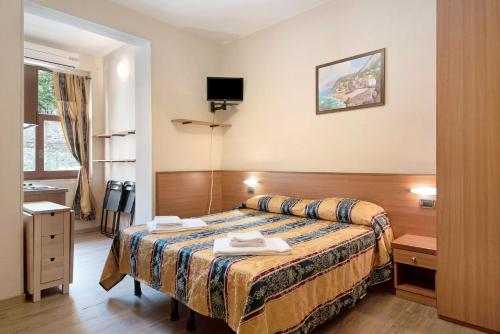 a hotel room with a bed and a television at Appartamento Monolocale Moneglia 25 in Moneglia