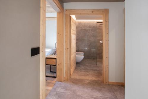 a bathroom with a toilet and a glass shower at Casa Ronden Mortirolo in Mazzo di Valtellina