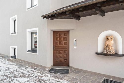 a building with an owl statue next to a door at La Grambla App Sella 1 in Santa Cristina Gherdëina