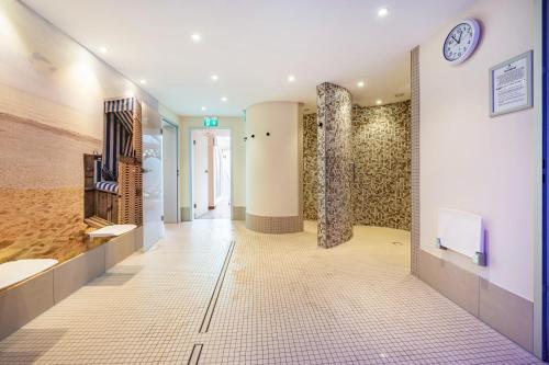 a hallway of a building with a clock on the wall at Apartementhaus Lord Nelson in Cuxhaven