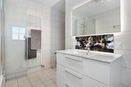 a white bathroom with a sink and a mirror at Ferienwohnung Vilstalstüble in Pfronten