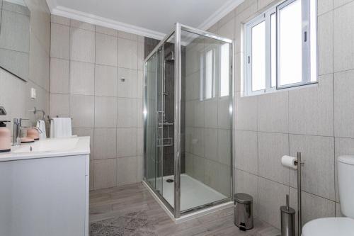 a bathroom with a shower with a glass door at Oásis Fonte Grande in Santo António