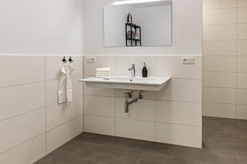 a white bathroom with a sink and a mirror at Omas Obstkiste in Stockach