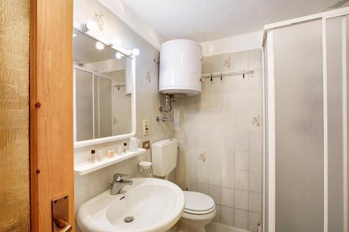 a bathroom with a white toilet and a sink at Lo Peiglo Valgrisenche in Valgrisenche