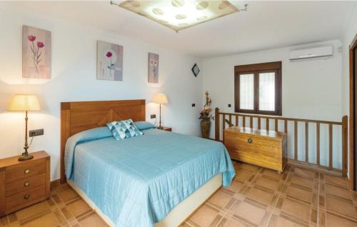 a bedroom with a bed with a blue bedspread at Casa Olivia in Cómpeta