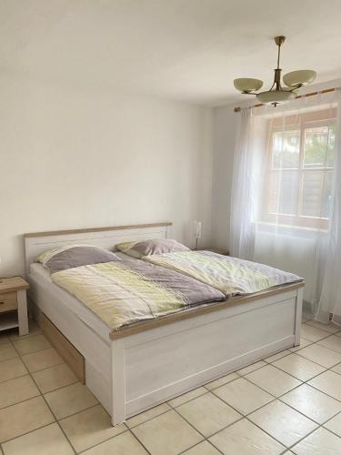 a white bed in a bedroom with a window at Ferienwohnung Starnberg in Starnberg