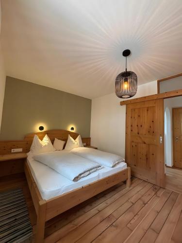a bedroom with a bed and a pendant light at Ferienwohnungen Zwick Spinei in Malles Venosta