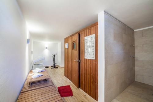 a bathroom with a shower and a wooden door at Gartenheim App Elisabeth in Schenna