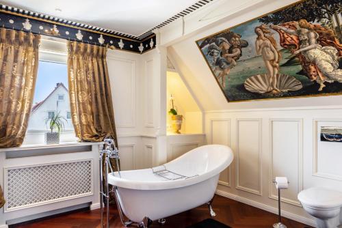 a bathroom with a tub and a painting on the wall at Ferienhaus Barockhaus Fulda in Petersberg