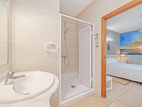 a bathroom with a sink and a shower and a bed at El Bosque in Llucmajor