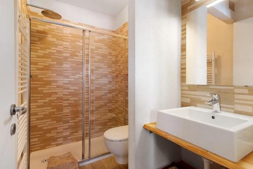 a bathroom with a toilet and a sink and a shower at Appartamenti Pila Vacanze 2 in Gressan