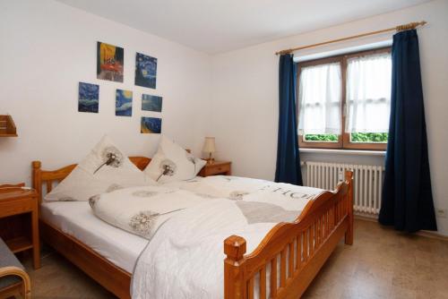 a bedroom with a wooden bed and a window at Ferienwohnung Reindler in Fischen