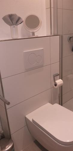 a white bathroom with a toilet and a mirror at Ferienwohnung Reindler in Fischen