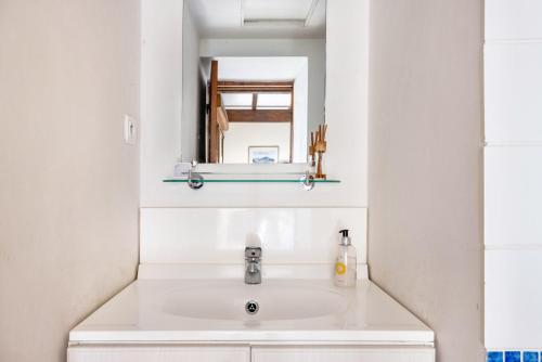 a bathroom with a sink and a mirror at Bourdeverre Chambres D'hôtes in Sanxay